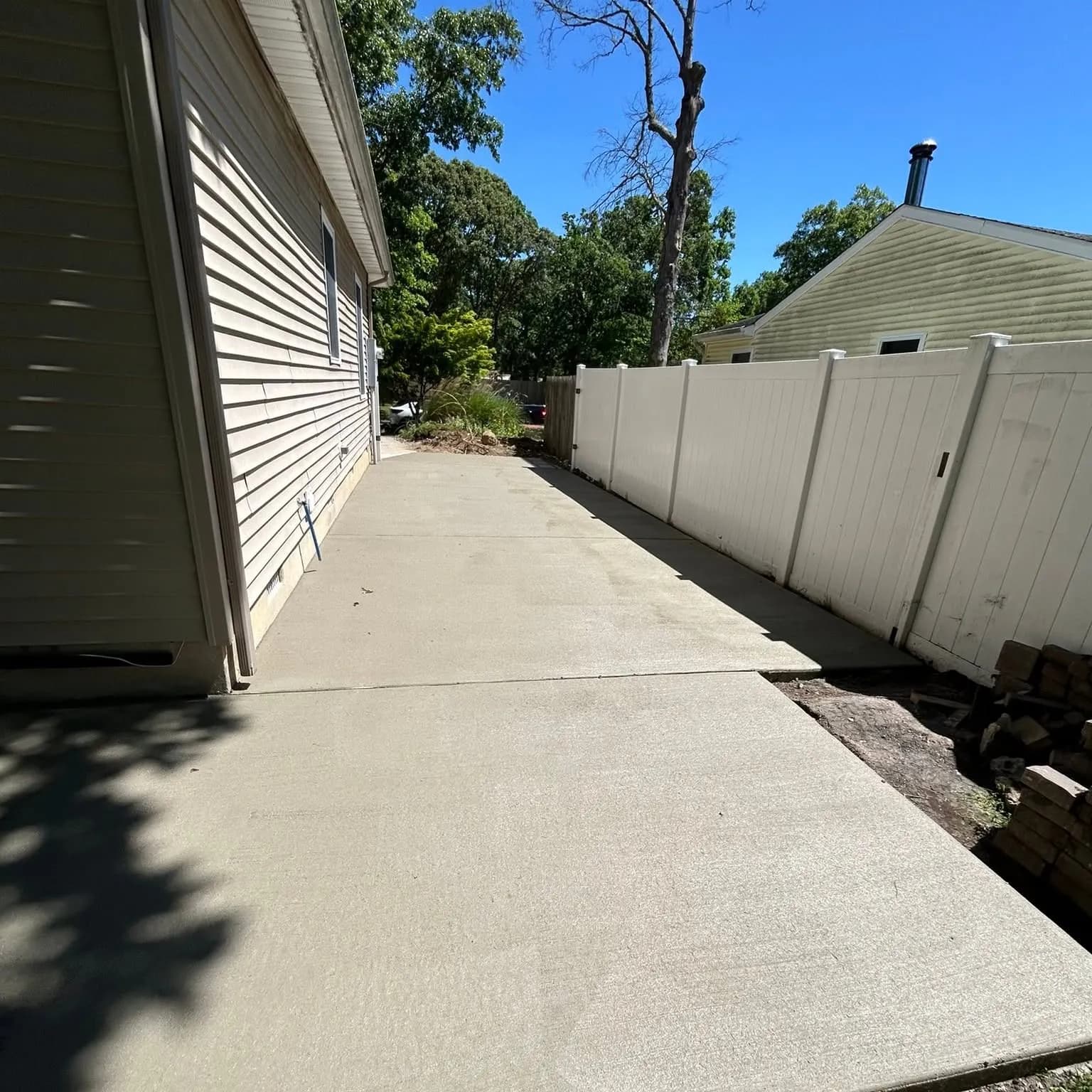 Concrete side-yard walkway between a home and fence in South Jersey